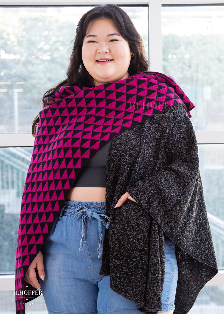 Ashley, an olive skinned XL model with long brown hair is wearing our open front poncho. One side is black triangles and pink triangles while the other is a heathered black.