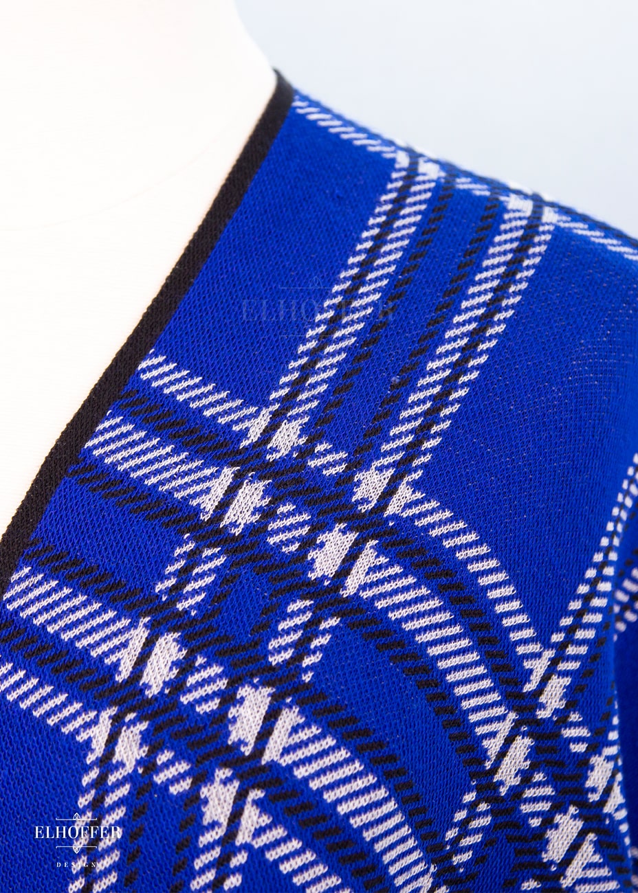 A close up of the knit texture and tartan pattern.