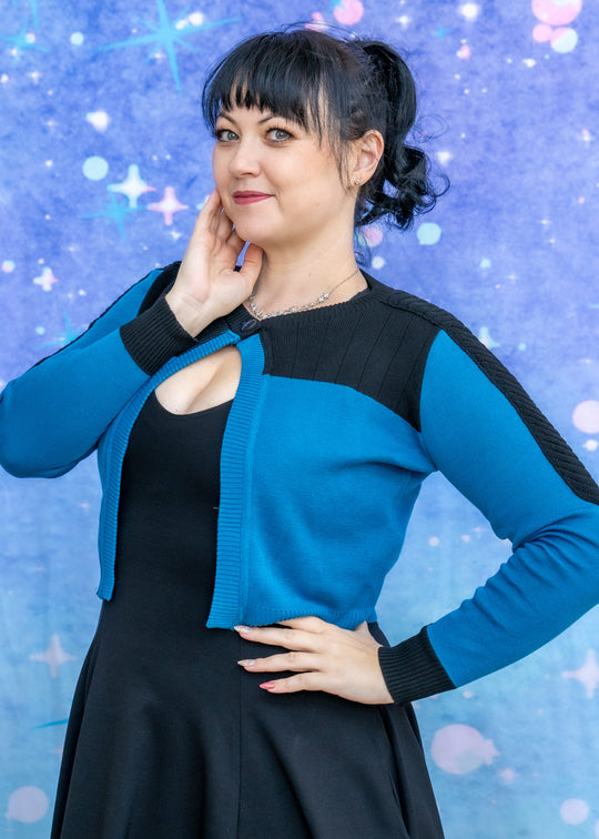 Woman wearing a blue and black outfit against a starry background