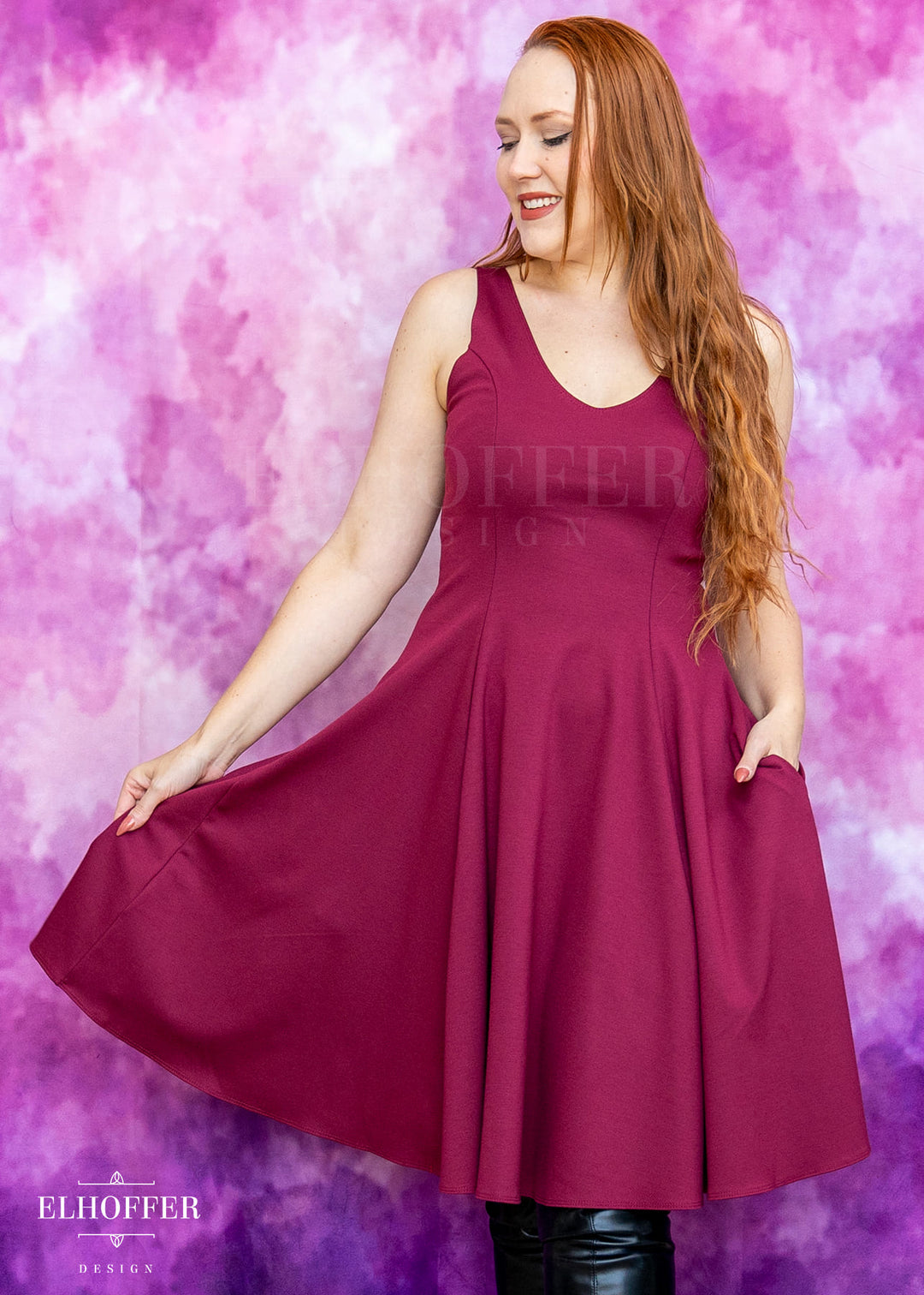 Woman wearing a burgundy dress against a pink and purple gradient background with 'Elhoffer Designs' branding.