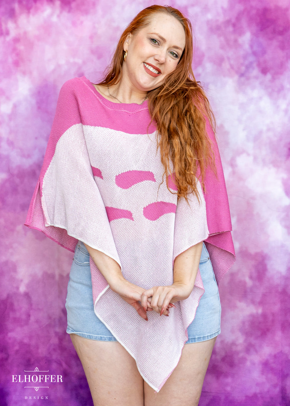 Woman wearing a pink and white poncho against a pink and purple gradient background