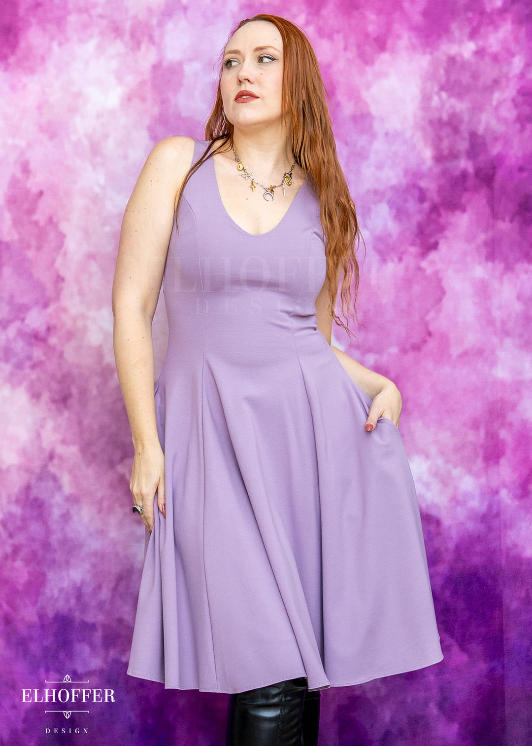 Woman wearing a purple dress against a pink and purple gradient background