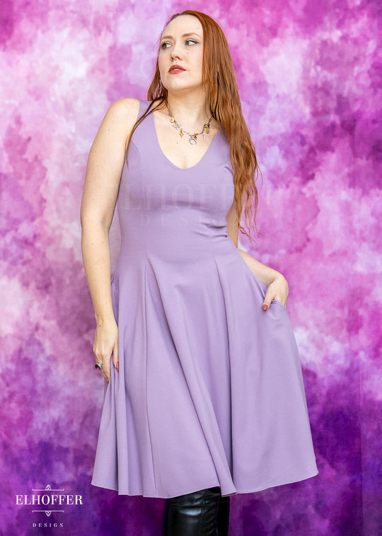 Woman wearing a purple dress against a pink and purple gradient background