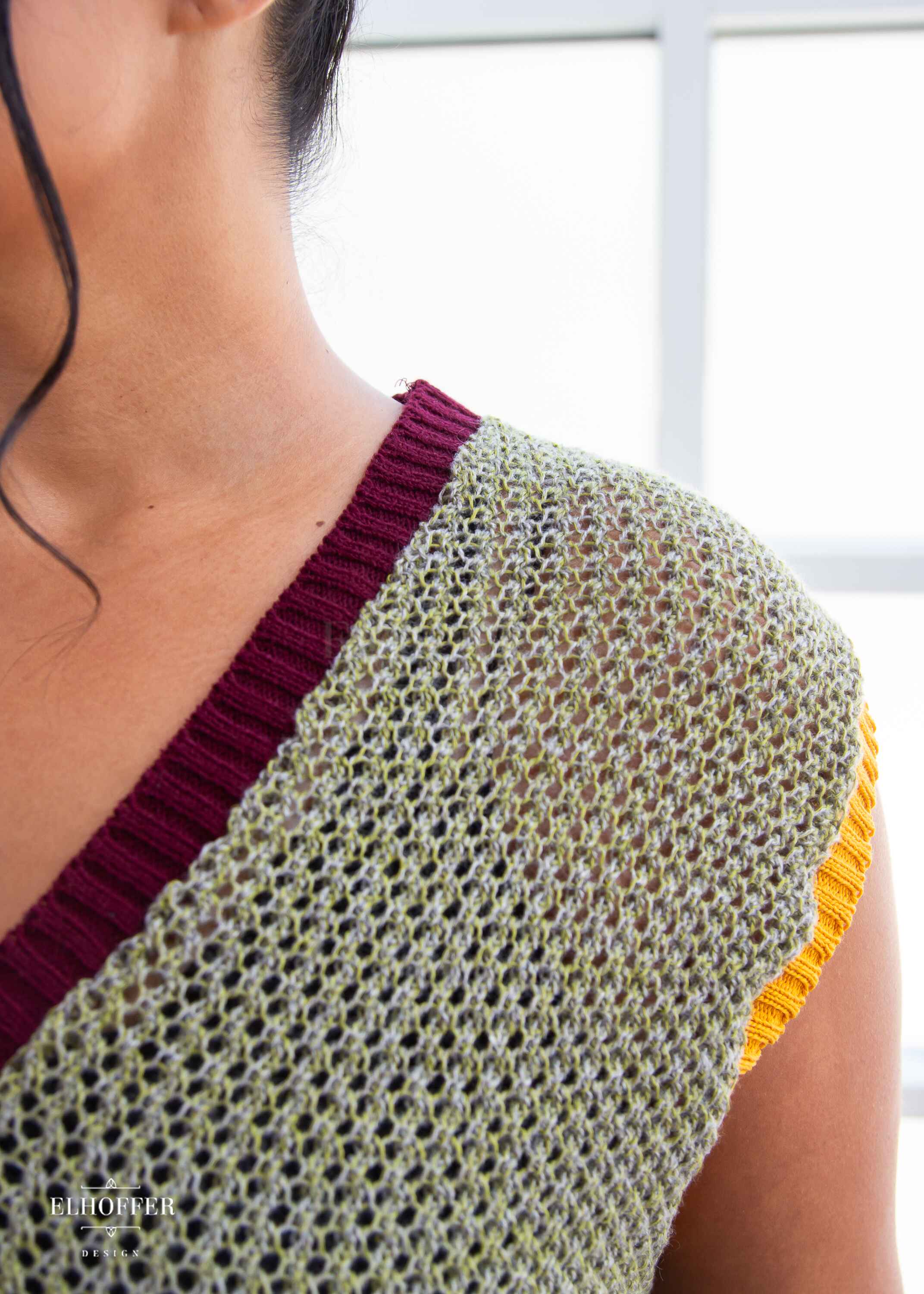 Close up of the loose weave knit and ribbing alone neckline and armhole.