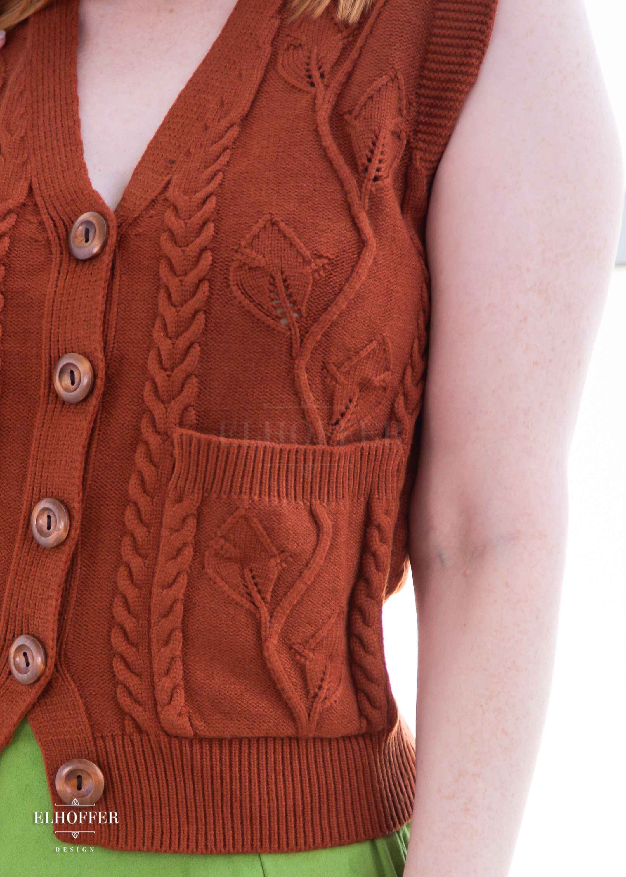 A closeup of the leafy vine and cable knit pattern in the vest