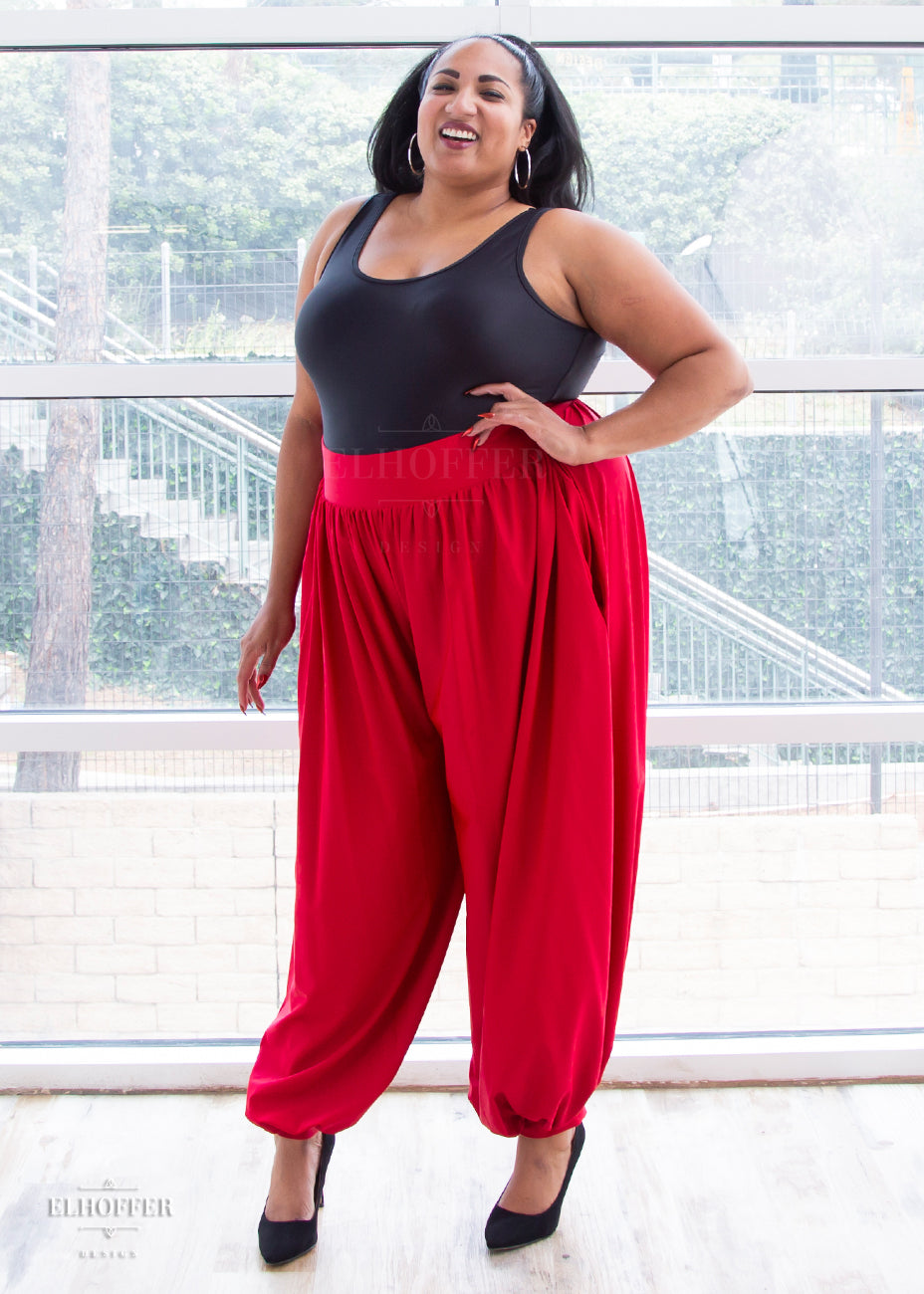Tas pairs the black bodysuit with the red Yasmin Pants, loose fitting "puffy" pants with fitted waist and cuffs.