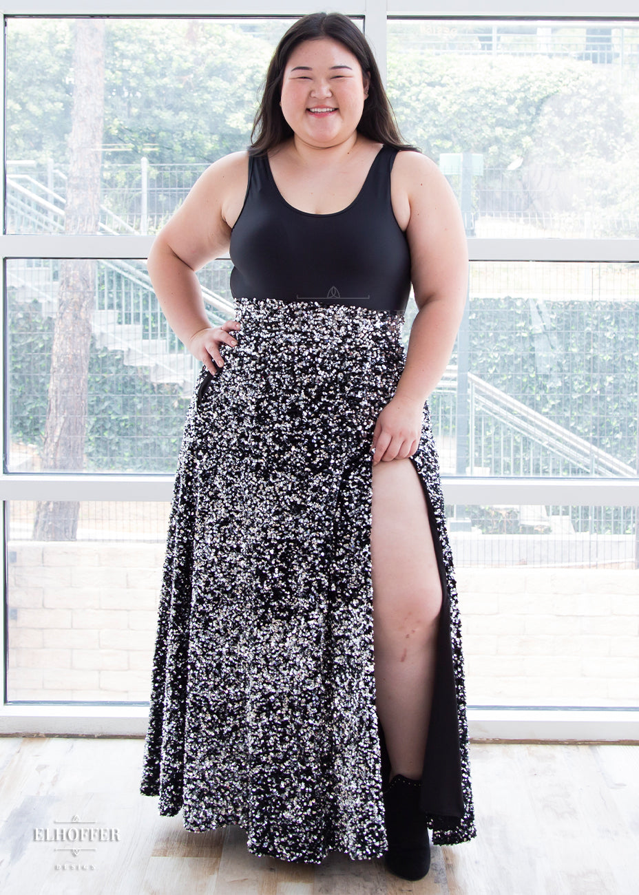 Ashley pairs the black bodysuit with a high waisted silver sequin skirt with thigh high slit and pockets.