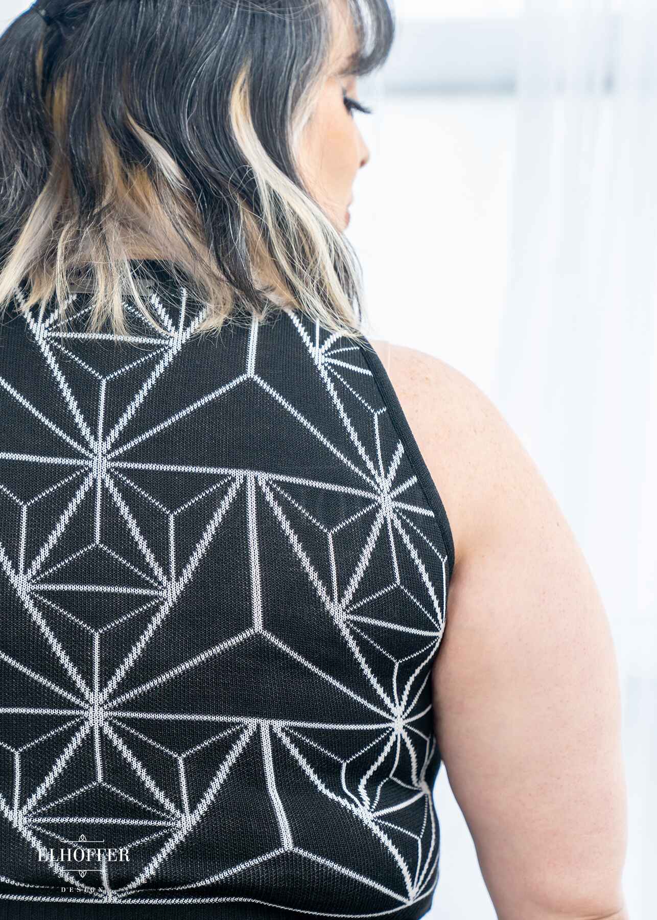Close up of the black sweater and the white geometric 3D triangle pattern.