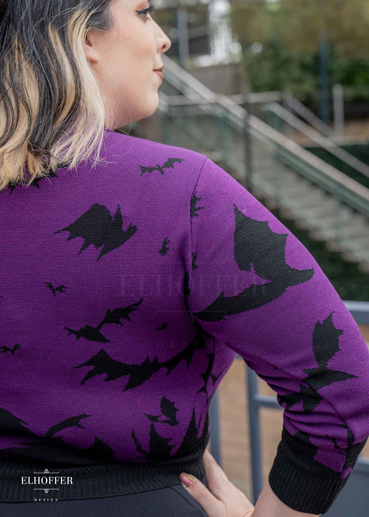 Close up of black bat design on purple sweater