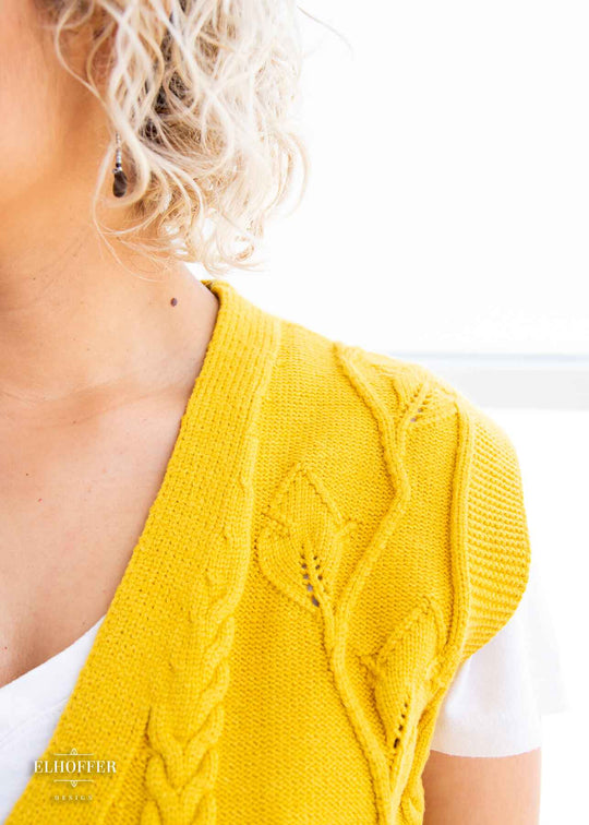  A close up of the leafy vine and cable knit pattern in the vest