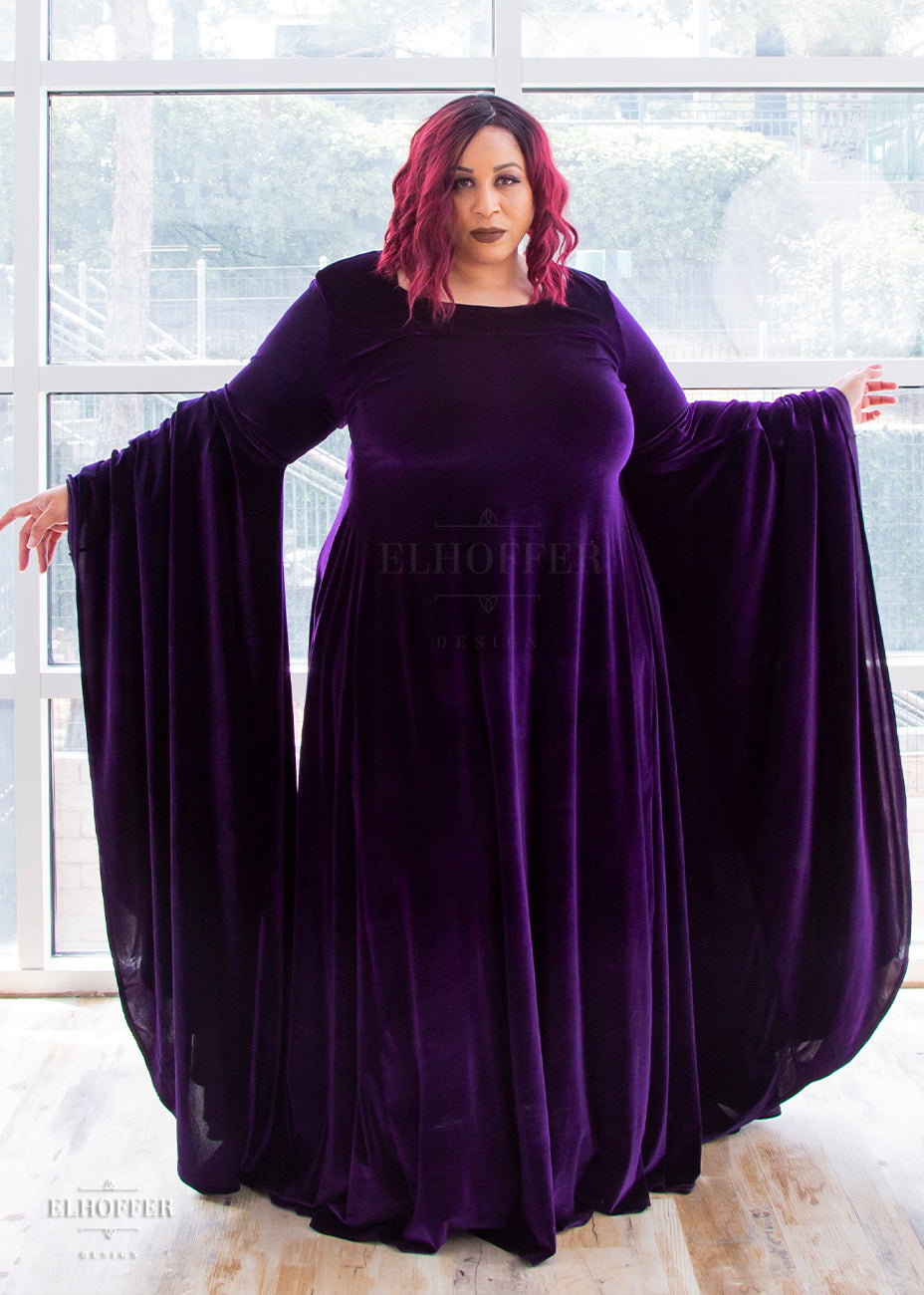 Dawn shows off the extra full and long sleeves of the dress. She wears the size 3X and her measurements are 49.5” Bust, 43” Waist, 56” Hips, and she is 5’6” tall.