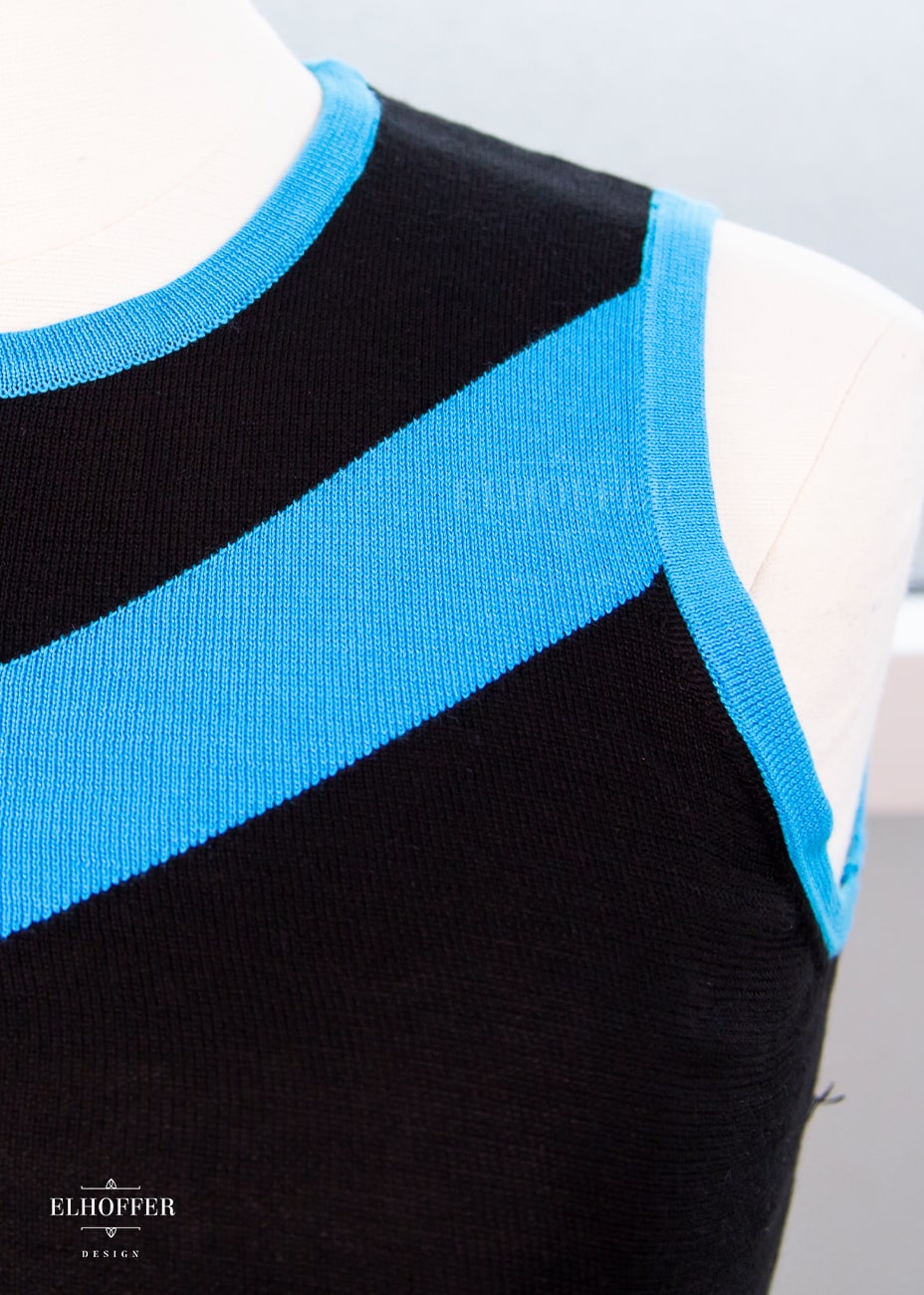 Close up of the shoulder of the tank top on a mannequin.  Showcasing the lightweight knit texture and the black and teal colors of the top.