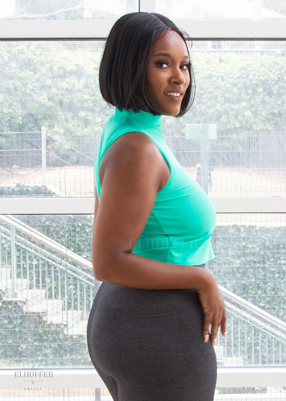 Lynsi pairs the mint green mock neck sleeveless crop top with heathered grey fitted leggings with back pockets.