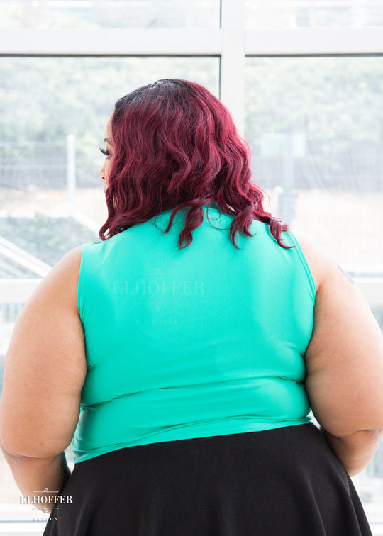 Dawn models the back of the mint green sleeveless crop top which covers her back and hits at her natural waist.