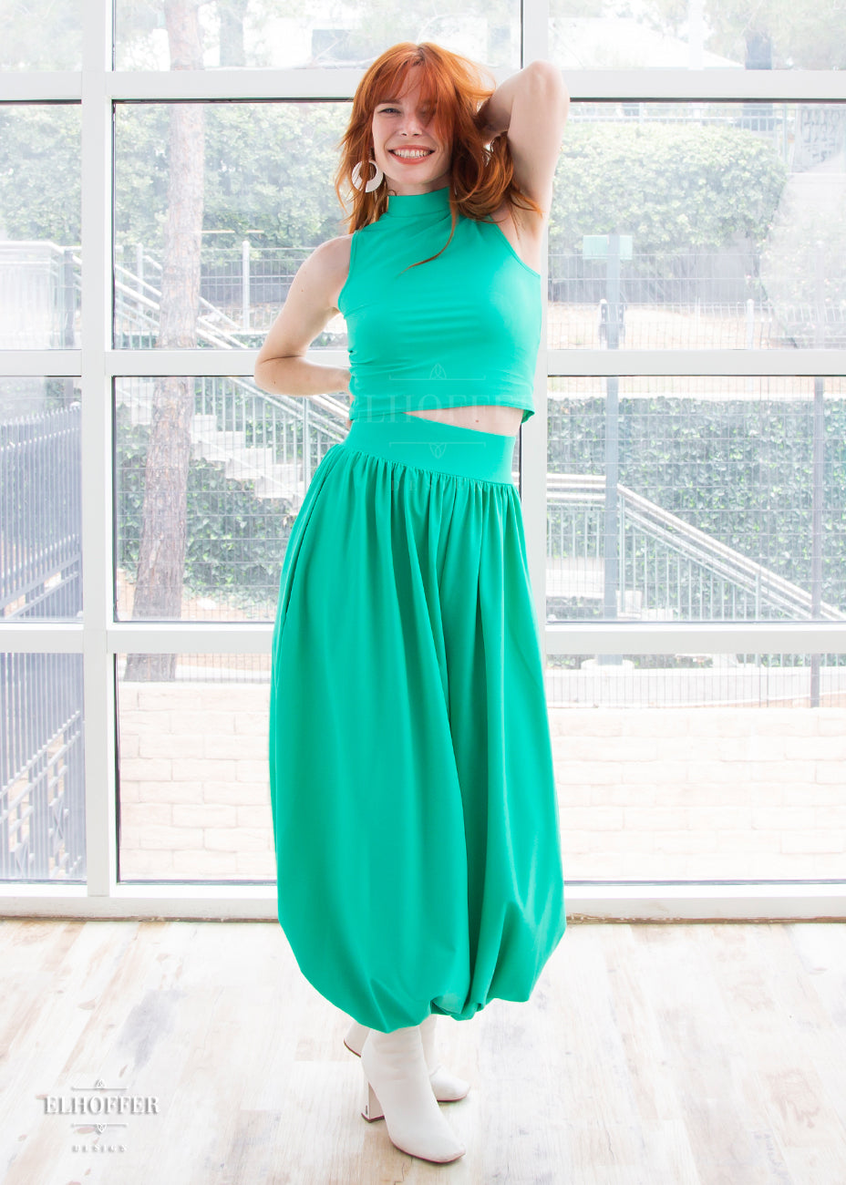Chloe models the mock turtle neck sleeveless mint green crop top with matching harem style long pants with a fitted waistband and cuffs and flowy fabric.