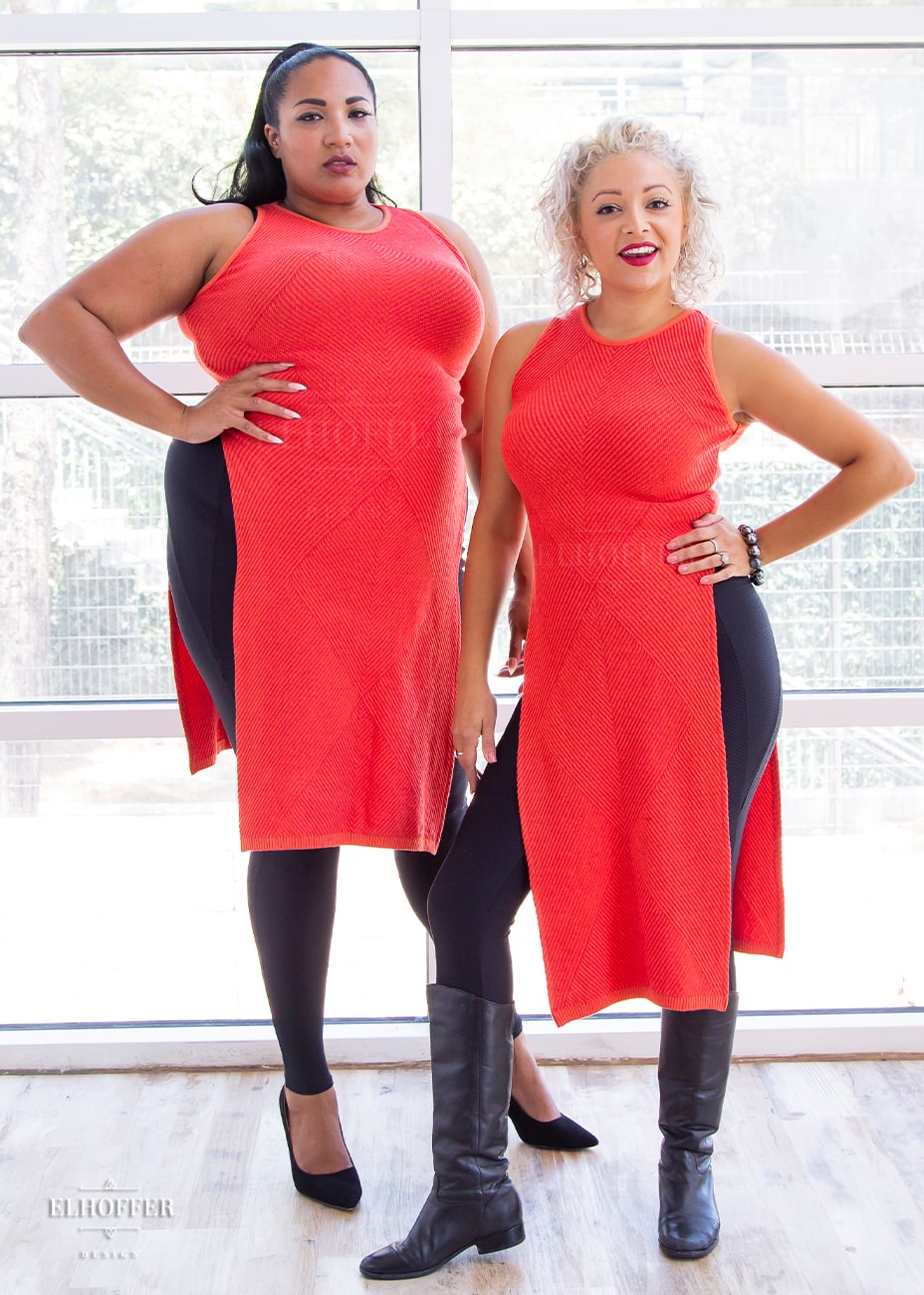 Tas, a medium dark skinned 2XL model with long black hair, and Simone, an olive skinned size small model with short curly platinum hair, are both wearing the orange tabard.